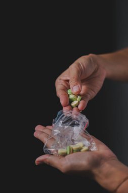 Yakın plan. Şişeden ilaç alan kadın elleri.