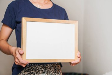 female holding blank white frame