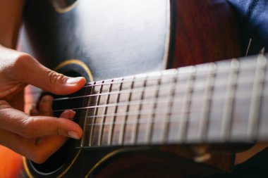 close up of man hands playing acoustic guitar