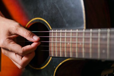 Adam akustik gitar çalıyor..