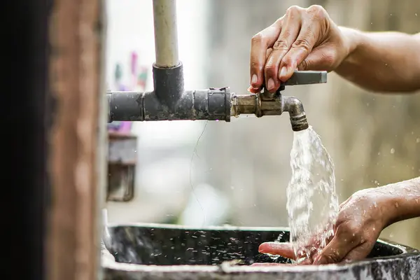 hands of man washing the tap