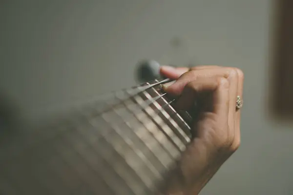 close - up of female hands holding guitar