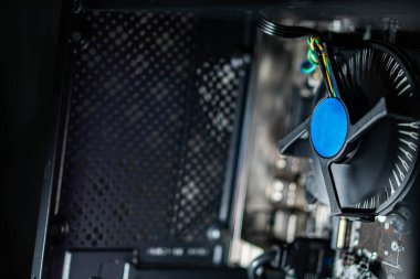 Görünür kablolar ve bileşenleriyle bir masaüstü bilgisayarının soğutma vantilatörünün yakın plan görüntüsü.