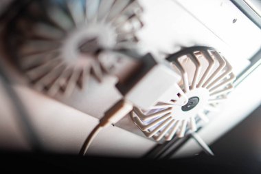 Bulanık arkaplanı olan bir aygıta bağlı bir USB hayranının yakın görüntüsü.