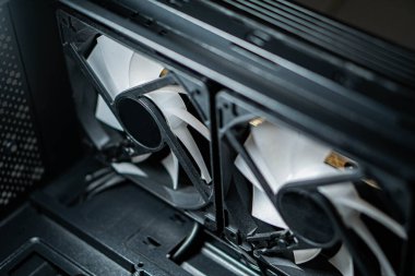 Bilgisayarların soğutma vantilatörlerini yakın çekimde açıp pervaneleri vurguluyor ve monte ediyor..