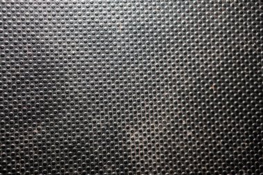 Close-up of a textured black surface with small circular bumps evenly distributed. clipart