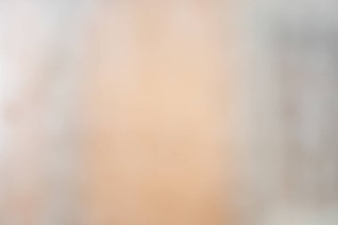 Belirsiz şekil ve renklere sahip bulanık bir görüntü, özellikle bej ve gri tonlarda..