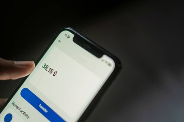 Bir finans uygulamasında 38.18 dolar denge gösteren akıllı bir telefon ekranının yakın çekimi.
