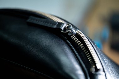 Gümüş fermuarlı siyah deri bir çantaya yakından bakın..