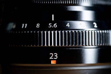 Bir kamera merceğinin açığı ve odak uzaklığı ayarlarını gösteren yakın çekimi. Açıklık halkası f / 5.6 ve odak uzunluğu 23 mm olarak ayarlanmıştır..