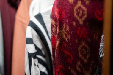 Dolapta asılı çeşitli desenli ve renkli kumaşların yakın çekimi..