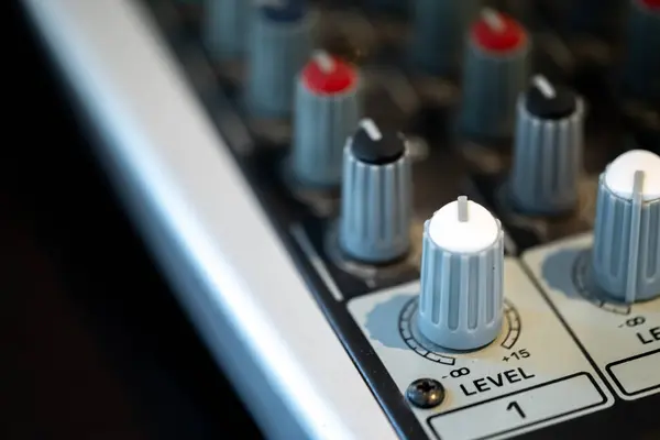 stock image Close-up of an audio mixer with various knobs and levels.