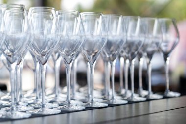 Bir masaya dizilmiş birden fazla boş şarap kadehinin yakın plan görüntüsü, bir etkinliğe ya da kutlamaya hazır..