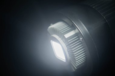Karanlık bir ortamda ısı gidericisi olan parlak bir LED ışığa yakın çekim.
