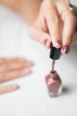 Tırnaklarına pırıl pırıl pembe oje süren birinin yakın çekimi..