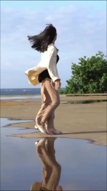 Güzel Asyalı kız sahilde poz veriyor.