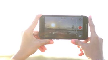 Kadın akıllı telefonla fotoğraf çekiyor.