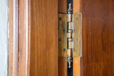 Kaliteli pirinç bir kapının yakın çekimi ahşap bir kapının menteşesi, karmaşık detaylar ve dokular sergiliyor..