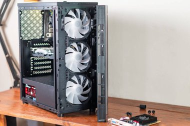 Görünür üç büyük soğutma vantilatörü olan bir bilgisayar çantası. İç bileşenleri göstermek için kısmen açık. Çanta ahşap bir yüzeye yerleştirildi.