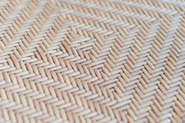 A close-up view of a woven pattern made from natural fibers, showcasing intricate geometric designs in beige and light brown tones. The texture is smooth and uniform, gig clipart