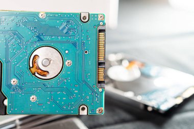Dahili devre kartı ve bileşenlerini gösteren bir sabit disk sürücüsünün (HDD) yakın plan görüntüsü. Görüntü, elektronik bağlantıların karmaşık detaylarını vurgular.