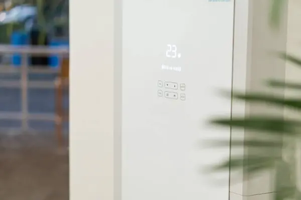 Modern bir klima ünitesinin, 23 derecelik bir dijital sıcaklık ölçümünü gösteren yakın çekim görüntüsü. Birim, kontrollü, gösterişli, minimalist bir tasarıma sahip.