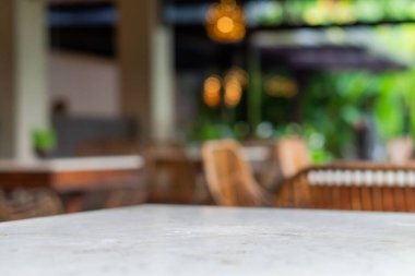 Canlı yeşil çimlerle dolu dekoratif bir kase, mermer bir masanın üzerine yerleştirilmiş. Arka planda yeşil ile bulanık doğal bir ortam var, dingin bir atmosfer yaratıyor..