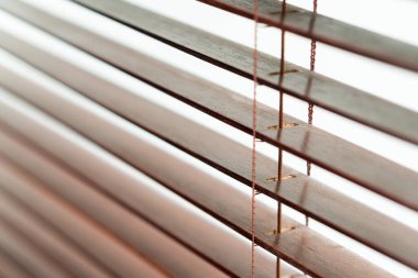 Yatay kirişlerle ahşap panjurlara yakın çekim, ahşabın dokusunu ve detaylarını gözler önüne seriyor. Işık boşluklardan süzülerek, yumuşak ve dağınık bir aydınlatma yaratıyor..