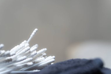 Yumuşak bir zeminde, arka planda bulanık pamuklu çubuklar üst üste yığılmış. Görüntü, örneklerin dokusunu ve detaylarını yakalıyor. Temizliklerini ve faydalarını vurguluyor..