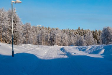 İskandinavya 'daki güzel beyaz kış harikalar diyarı manzarasının panoramik manzarası kışın gün batımında, kuzey Avrupa' da manzaralı altın akşam ışığı. İsveç Laponya.