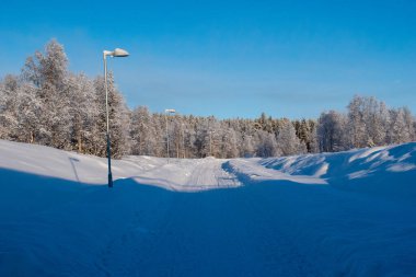 İskandinavya 'daki güzel beyaz kış harikalar diyarı manzarasının panoramik manzarası kışın gün batımında, kuzey Avrupa' da manzaralı altın akşam ışığı. İsveç Laponya.