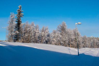 İskandinavya 'daki güzel beyaz kış harikalar diyarı manzarasının panoramik manzarası kışın gün batımında, kuzey Avrupa' da manzaralı altın akşam ışığı. İsveç Laponya.