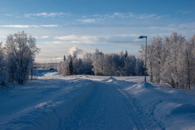 İskandinavya 'daki güzel beyaz kış harikalar diyarı manzarasının panoramik manzarası kışın gün batımında, kuzey Avrupa' da manzaralı altın akşam ışığı. İsveç Laponya.