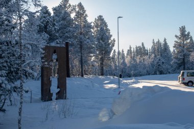 Kış manzarasında metal bir balığın çizimi. İsveç Laponya.
