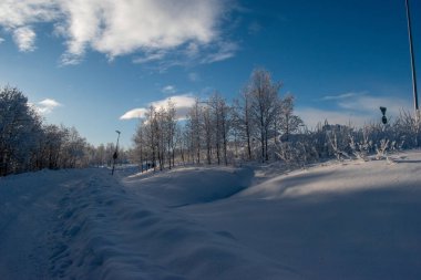 Kuzey Kutbu 'nda bol kar ve mavi gökyüzü ile panoramik soğuk kış manzarası. Fotoğraflar Kiruna, İsveç Laponya.
