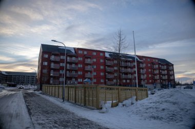 22 Mart 2025. İsveç Laponya 'nın kuzeyinde küçük bir kasaba olan Kiruna' nın yeni şehir merkezi. Kışın gün batımında çekilmiş..