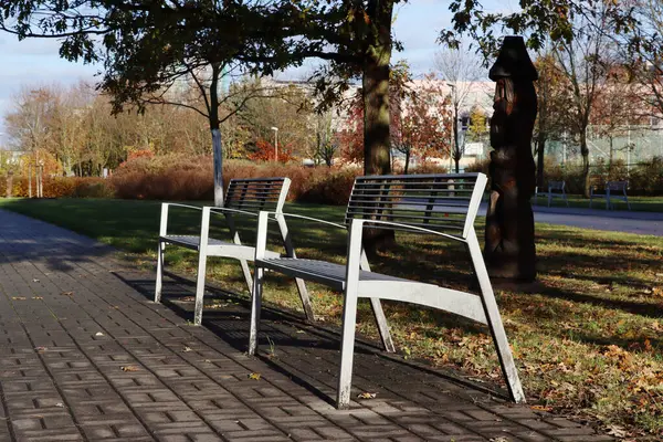 Two metal benches in the sunlight, autumn atmosphere