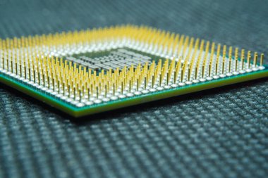 Bilgisayar ya da laptop işlemci işlemcisinin makro fotoğrafı. Metalik altın raptiyeler ve bilgisayar işlemcisinin yeşil PCB 'si. Yarı iletkenler, iğneler ve bağlayıcılar. Seçici odak. 