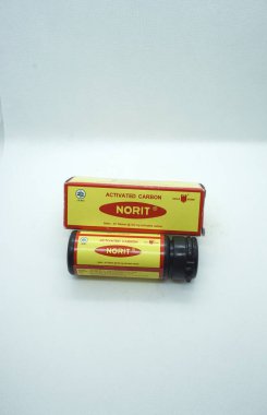 İshal ve gazın tedavisinde kullanılan aktif karbon tabletinin izole edilmiş beyaz arka planı olan NORIT 'nin üst görüntüsü.