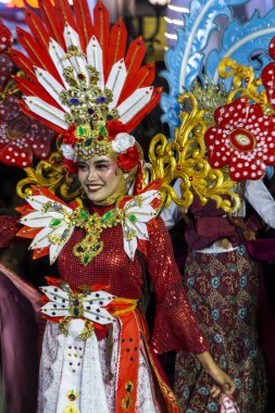 Yogyakarta, Endonezya-6 Ağustos 2025: Canlı bir sokak geçidi sırasında renkli geleneksel giysiler içinde kültürel mirası sergileyen katılımcılar. Görüntü neşeyi, sanatçılığı ve kutlamaları yansıtıyor. Benzersiz süsleri vurguluyor.