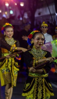 Yogyakarta, Endonezya-6 Ağustos 2025: Kültürel bir festivalin canlı bir tasviri dansçıları karmaşık geleneksel kıyafetler ve parlak, renkli ışıklandırmalarla, sanatsal performanslar yoluyla neşe ve birliği ifade eden sanatsal gösteriler.