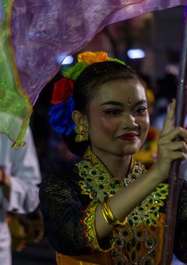Yogyakarta, Endonezya-6 Ağustos 2025: Canlı kültürel kutlama, elinde bayrakla geleneksel giyinmiş bir katılımcının yakın çekimi ile çekildi.