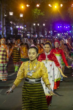 Yogyakarta, Endonezya-6 Ağustos 2025: Canlı bir gece sahnesinde geleneksel dansçıların dekoratif ışıklar altında renkli kıyafetler giyip çeşitli sanatsal performanslar sergiledikleri bir kültür geçit töreninde görüntülendiler..