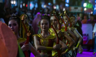 Yogyakarta, Endonezya-6 Ağustos 2025: Renkli geleneksel kıyafetler giymiş canlı bir grup kadın, kültürel sanatçılık ve birlik sergilenen şenlikli bir gece etkinliğinde anlamlı dans ediyorlar..