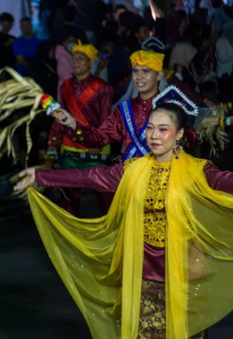 Yogyakarta, Endonezya-6 Ağustos 2025: Canlı geleneksel kostümler içinde dans eden, neşeli ışıklar altında gösteri yapan ve eşsiz bir tören gösterisine katılan enerjik bir kültürel kutlama..