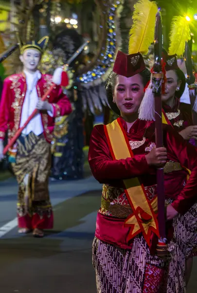 Yogyakarta, Endonezya-6 Ağustos 2025: Geleneksel kıyafet geçidine katılanlar kültür ve mirası sergileyen bir festival gecesinde geçit töreni yapıyorlar. Renkli kostümler, kültürel müzik ve dans geleneği kutlayan canlı bir atmosfer yaratır. 