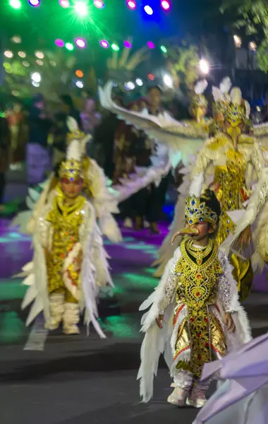 Yogyakarta, Endonezya-6 Ağustos 2025: Renkli ve çetrefilli kostümlerle süslenmiş çocuklar, neşeli ve kültürel açıdan önemli bir atmosfer yaratan, aydınlatma ve dekoratif kanatlarla çevrili canlı bir geçide katılıyorlar..