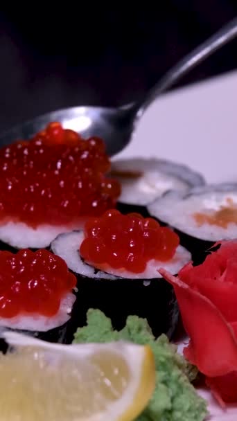 棒店内の照明を背景に寿司を取る 赤キャビア フィラデルフィアチーズ 箸休めの寿司の種類が豊富です 石板においしい日本の寿司ロールのセット — ストック動画
