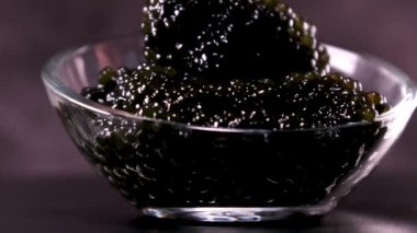 Masa arkasında siyah ve kırmızı havyar olan bölünmüş bir tabak. Yüksek kalite fotoğraf