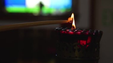 Mumun yakıldığı makro çekim. Siyah arkaplan önünde yanıp sönen kırmızı mum. Yüksek kalite 4K görüntü.